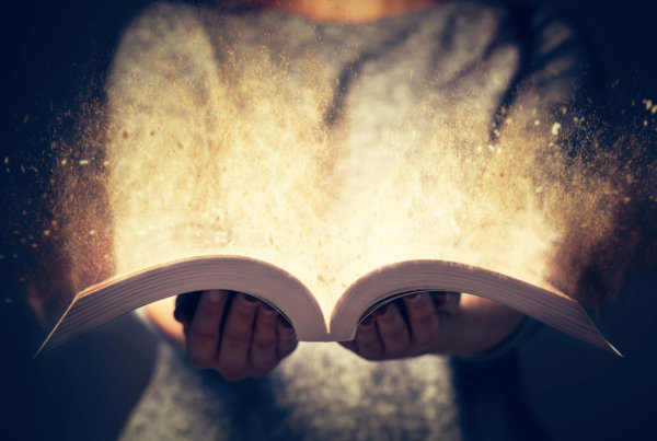 Person holding a book with magic coming out of it.